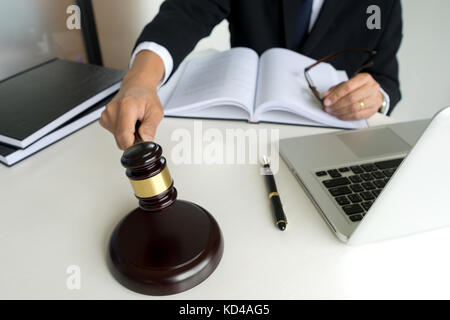 Giudice statuire in aula arbitro hammer il martello sul tavolo con laptop notebook. Foto Stock