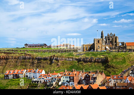 Veduta della chiesa e le rovine dell'Abbazia sulla cima della scogliera sopra la città di Whitby Foto Stock