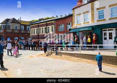 Persone che fanno la coda fuori dal negozio Fish n' chip a Whitby NE Yorkshire Regno Unito Foto Stock