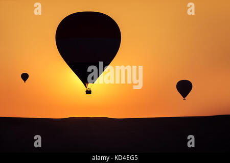 Silhouette di mongolfiere volare sopra la valle in Cappadocia, Turchia. Foto Stock