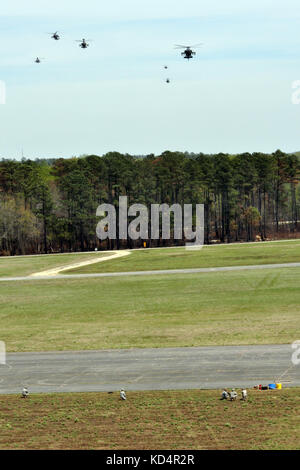 AH-64 elicotteri Apache dal 1-151esimo Battaglione di ricognizione attacco, South Carolina Army National Guard, si ricarica dopo aver condotto un attacco di interdipendenza di dimensioni battaglione su Poinsett Range, Sumter, S.C., 5 aprile 2014. Durante questo esercizio, il 1-151st ARB ha lanciato 18 Apaches per praticare la libera formazione del movimento, che è una missione aerea di attacco vitale che fornisce copertura aerea per le truppe di terra. (Foto della Guardia Nazionale di Capt. Jamie Delk/RILASCIATA) Foto Stock