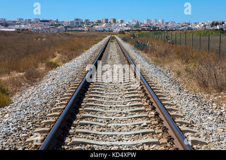 Una vista lungo la linea ferroviaria che corre lungo il sud del Portogallo costa. la famosa città turistica di lagos è in distanza. Foto Stock
