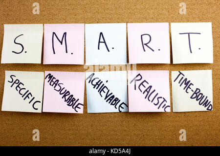Un bigliettino giallo iscritto, didascalia, iscrizione frase smart in nero ext su un foglietto adesivo imperniato ad un tappo di sughero bacheca specifici, misurabili, raggiungibili, registrati, tempestiva colorato sticky notes sul sughero bulletin board Foto Stock