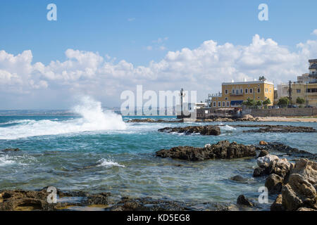 Le onde del mare con il vecchio faro nel pneumatico, aspro, Libano Foto Stock