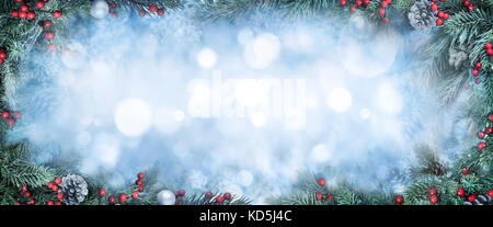 Sfondo di natale con il pupazzo di neve Abete rami come una cornice intorno blue bokeh spazio copia Foto Stock