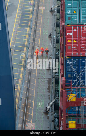 Stevedores sul dock a fianco di un contenitore nave al porto di Felixstowe Foto Stock