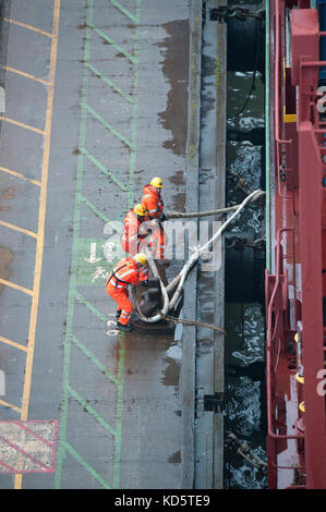 Stevedores sul dock a fianco di un contenitore nave al porto di Felixstowe Foto Stock