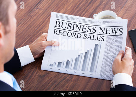 Close-up del giovane imprenditore per leggere le notizie sul giornale Foto Stock