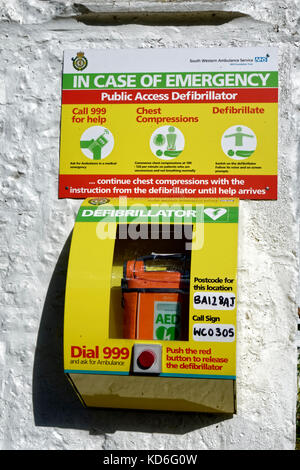 Un defibrillatore ad accesso pubblico collegato alla parete esterna del Bath Arms Pub a Crockerton, Wiltshire, Regno Unito Foto Stock