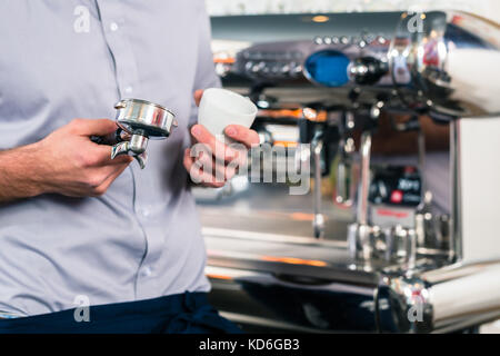 Cameriere di preparare l'espresso in un sistema automatico di macchina per il caffè Foto Stock