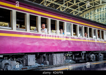 I passeggeri seduti in attesa sul treno a una piattaforma in hua lamphong stazione ferroviaria Bangkok in Thailandia. Foto Stock