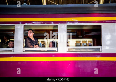 I passeggeri seduti in attesa sul treno a una piattaforma in hua lamphong stazione ferroviaria Bangkok in Thailandia. Foto Stock