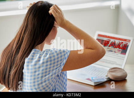 Realizzando la donna che ha utilizzato un sito web falso Foto Stock