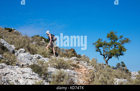 Una donna che cammina nei pressi del villaggio di Anogi fino alla vetta del Monte Nirito il punto più alto dell'isola di Itaca nel Mar Ionio della Grecia settentrionale Foto Stock