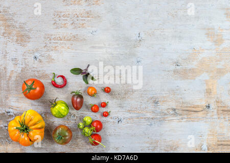 Produzione biologica antica varietà di pomodori sul vecchio bianco tavolo in legno con spazio di copia Foto Stock