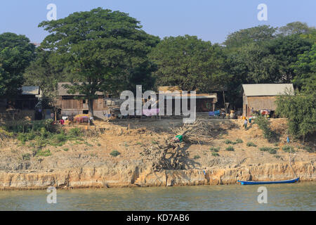 Gli abitanti di un villaggio di salire la riva del fiume a ngazun villaggio sul fiume Irrawaddy in Myanmar (Birmania) dopo il lavaggio nel fiume. Foto Stock