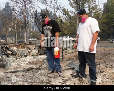 Santa Rosa, Stati Uniti. 10 ottobre 2017. Michael Nills (R) e Jimmy Duncan osservano il quartiere bruciato, indossando maschere protettive a Santa Rosa, Stati Uniti, 10 ottobre 2017. Le auto sono state ridotte a rottami, gli edifici sono bruciati a un guscio. Molti californiani ritornano a un incubo. Credito: Barbara Munker/dpa/Alamy Live News Foto Stock