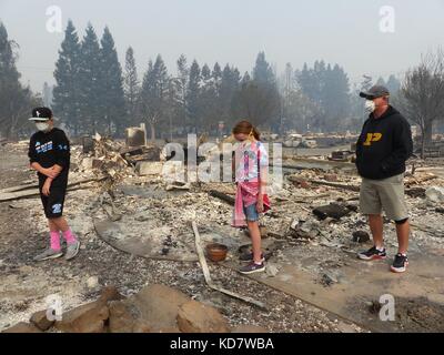 Santa Rosa, Stati Uniti. 10 ottobre 2017. Anthony D'amico e i suoi figli Gio (L) e bella cercano di salvare oggetti nel quartiere bruciato, indossando maschere protettive a Santa Rosa, Stati Uniti, 10 ottobre 2017. Le auto sono state ridotte a rottami, gli edifici sono bruciati a un guscio. Molti californiani ritornano a un incubo. Credito: Barbara Munker/dpa/Alamy Live News Foto Stock