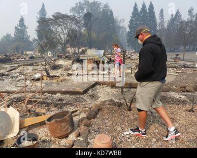 Santa Rosa, Stati Uniti. 10 ottobre 2017. Anthony D'amico e sua figlia bella cercano di salvare oggetti nel quartiere bruciato, indossando maschere protettive a Santa Rosa, Stati Uniti, 10 ottobre 2017. Le auto sono state ridotte a rottami, gli edifici sono bruciati a un guscio. Molti californiani ritornano a un incubo. Credito: Barbara Munker/dpa/Alamy Live News Foto Stock