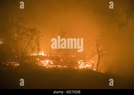 Napa County, Stati Uniti. 10 Ott 2017. Una struttura brucia a terra al fuoco di Atlas martedì sera. I proprietari dicono che le due strutture erano un garage e un'unità di affitto vacante.l'Atlas Fire brucia nelle contee di Napa e Solano lunedì sera 10 ottobre 2017. Il fuoco era contenuto al 3% e aveva bruciato 25,000 acri. Le strutture multiple sono state distrutte mentre gli equipaggi hanno combattuto i venti forti e la vegetazione asciutta di toder dopo gli incendi multipli bruciati nella zona. Credit: Stuart Palley/ZUMA Wire/Alamy Live News Foto Stock