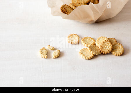 In casa croccante sottile cheesy crackers su bianco tavolo in legno - organico fresco in casa la cottura cheese crackers snack Foto Stock