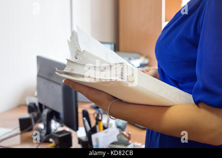 Ufficio femmina lavoratori holding sono disporre di documenti di incompiuta documenti sulla scrivania in ufficio, risma di carta aziendale. Foto Stock