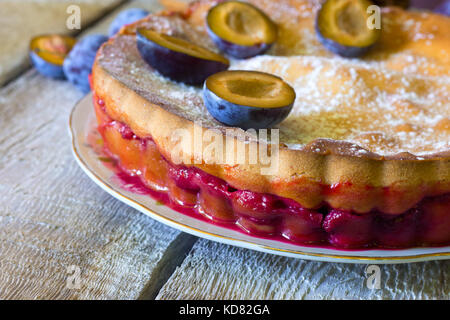 Torta di prugne e prugne fresche sul tavolo rustico. Foto Stock