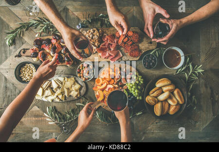 Flat-lay della compagnia di amici a mangiare e a bere insieme. Vista dall'alto di un gruppo di persone aventi una parte, raccolta, celebrazione o cena insieme seduta Foto Stock