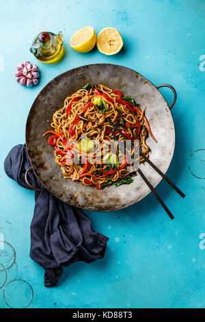 Udon STIR FRY Tagliatelle con funghi Oyster e verdure in padella wok su sfondo blu Foto Stock