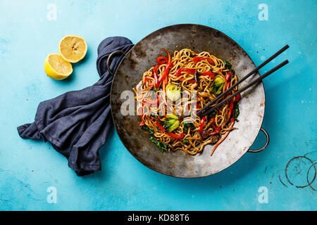 Udon STIR FRY Tagliatelle con funghi Oyster e verdure in padella wok su sfondo blu Foto Stock