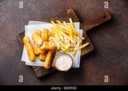 I bastoncini di pesce e patatine british fast food con salsa tartara su sfondo scuro Foto Stock