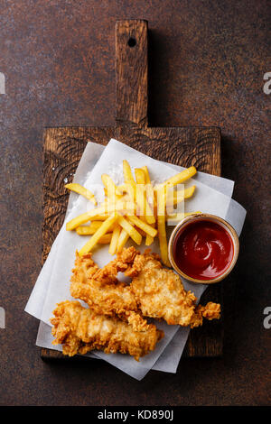 Pesce e Patatine british fast food con ketchup salsa su sfondo scuro Foto Stock