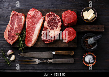 Varietà di materie Black Angus Prime bistecche di carne di lama sul tessuto osseo, Controfiletto, la nervatura occhio filetto filetto mignon su tavola di legno e la stagionatura Foto Stock