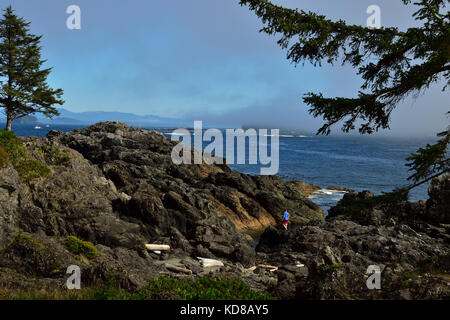 Un giovane uomo di esplorare la costa rocciosa linea lungo la west coast trail vicino Ucluelet sull'Isola di Vancouver British Columbia Canada. Foto Stock