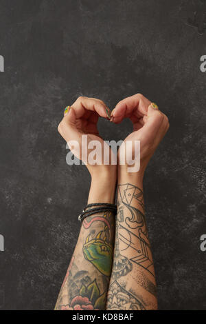 Mani femminili con tatuaggi a forma di cuore Foto Stock