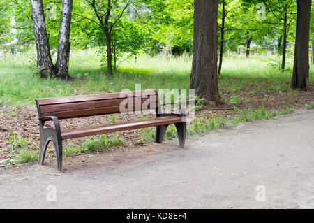 Percorso con banco in un tranquillo parco di estate. sfondo, natura. Foto Stock