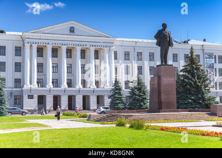 Pskov, Russia - Luglio 11, 2014: lenin monumento dal periodo sovietico si erge di fronte a pskov università statale. la gente comune a piedi sulla piazza Foto Stock