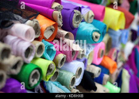 Vari rotoli di colorati per abbigliamento in un negozio. Pronto ad acquistare per la fabbricazione e la sartoria. Foto Stock