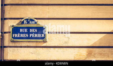 Blue strada parigina segno su un muro di pietra dove è scritto in francese - sedicesimo arrondissement rue perier fratelli Foto Stock