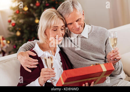 Felice coppia seduti insieme in salotto Foto Stock