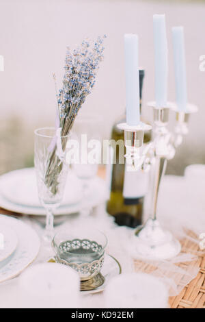 Bella tabella di nozze la composizione set. ferro cup vicino alla candela stand. Foto Stock