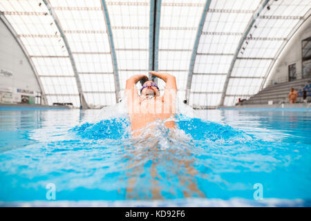 Uomo di nuoto nella piscina coperta. Professional nuotatore la pratica in piscina. Foto Stock