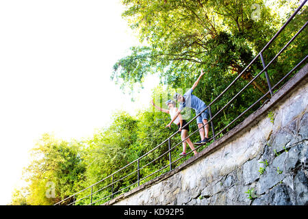 Bella giovane coppia in una passeggiata in città, in piedi su un ponte, indossando la realtà virtuale occhiale . soleggiata giornata di primavera. Foto Stock