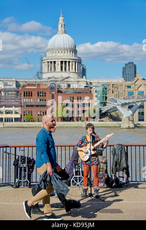 Londra, Inghilterra, Regno Unito. Busker (Gabriela Eva) sulla banca del sud, oltre il Tamigi dalla Cattedrale di St Paul Foto Stock