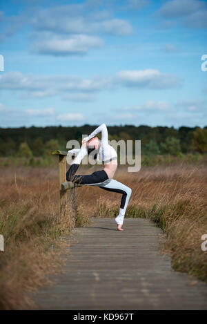 Donna facendo una posa yoga Foto Stock