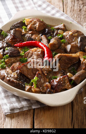 Spezzatino di manzo con bosco selvatico funghi e peperoncino close-up in un recipiente verticale. Foto Stock