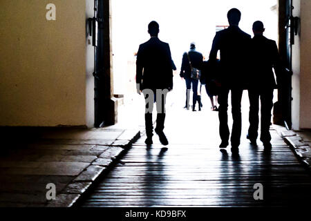 Un gruppo di uomini in giacca passeggiate Foto Stock
