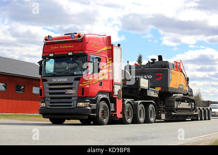 Koski tl, Finlandia - 7 maggio 2017: rosso scania r560 semi rimorchio di kosken autokeskus inizia la consegna di Volvo EC380 el escavatore cingolato lungo l'autostrada MI Foto Stock