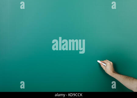 Mano azienda chalk scrivere sulla lavagna verde Foto Stock