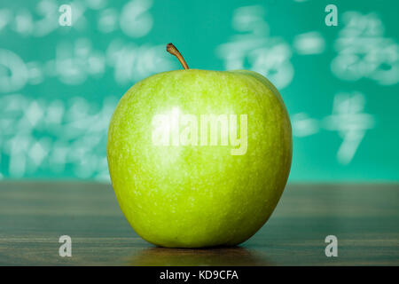 Foto di mela verde sul banco di scuola Foto Stock